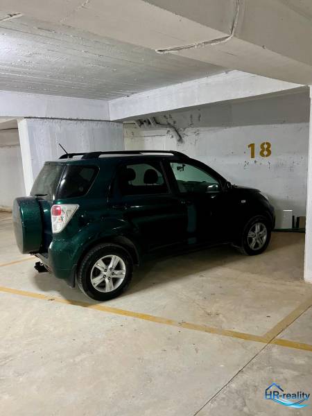 Auto zaparkované v garáži na parkovacím místě číslo 18.