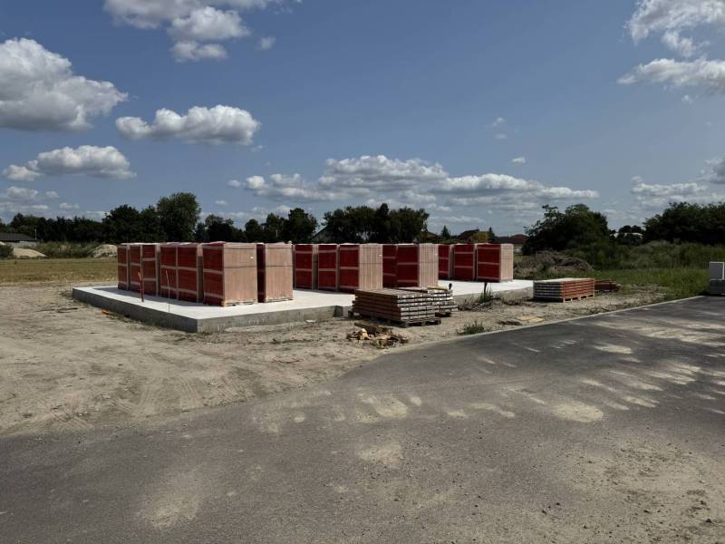 Základy rodinného domu v Horním Baru na otevřeném stavebním pozemku s materiálem.