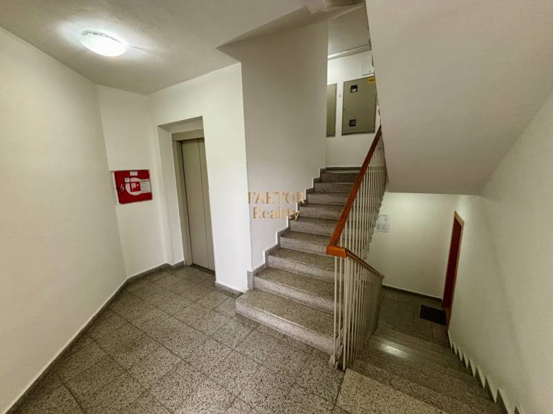 Schodiště s výtahem a protipožárními dveřmi v 2-pokojovém bytě.