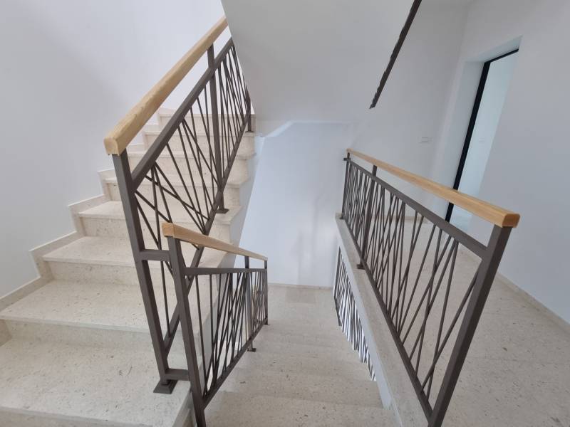 Schodiště s kovovým zábradlím ve 4pokojovém bytě.