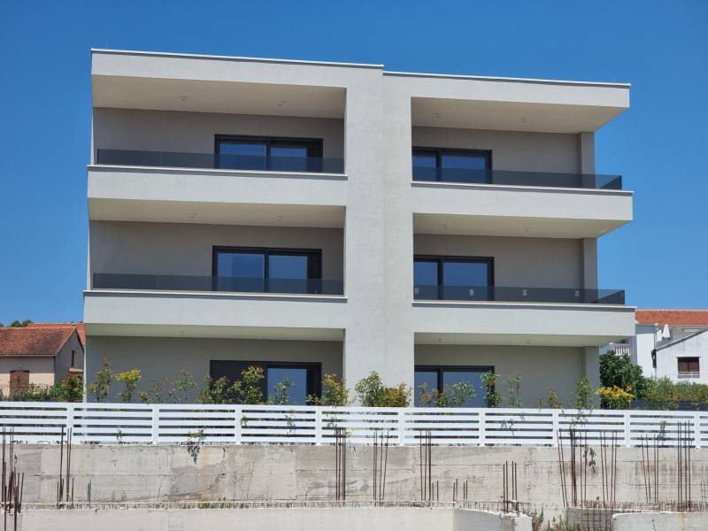Bytový dům ve městě Vodice se třemi patry a prosklenými balkóny.