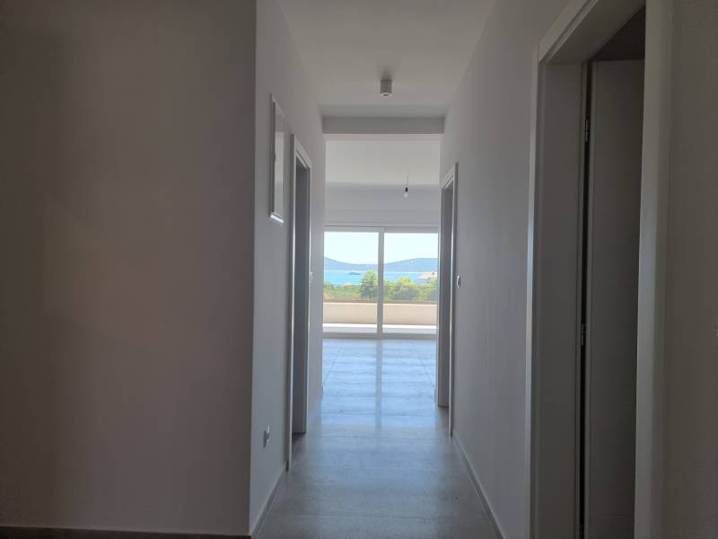 Koupelna ve 4-pokojovém bytě s chodbou a výhledem na balkon.