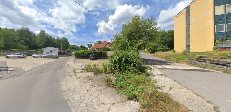 Pozemky - komerční na Štrajkové ulici v Handlové, se zelení a parkovištěm.