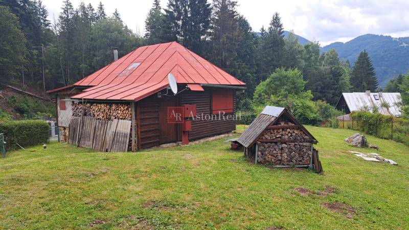 Chata v Nižním Matejkově v Ružomberku obklopená lesy se skladem dřeva.