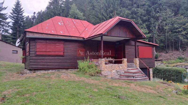 Rekreační chata a okolí v Ružomberku na Nižním Matejkově, před hustým lesem.