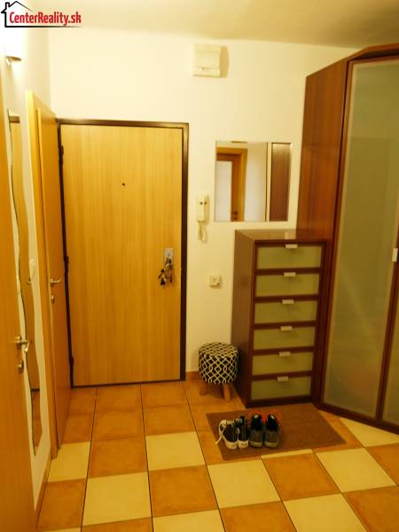 Předsíň v 3-pokojovém bytě s dlažbou a úložným prostorem, viditelné zrcadlo.