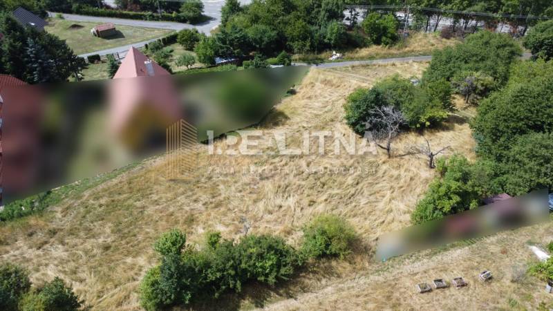 Stavební pozemky - bydlení v Banské Štiavnici na SNP, obklopené trávou a stromy.