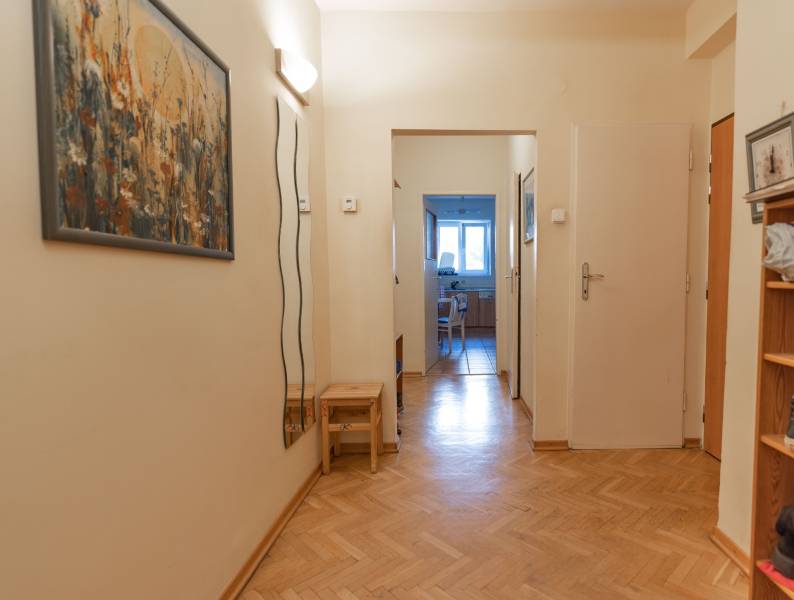 Chodba ve 4-pokojovém bytě s plovoucí podlahou a obrazem na stěně.