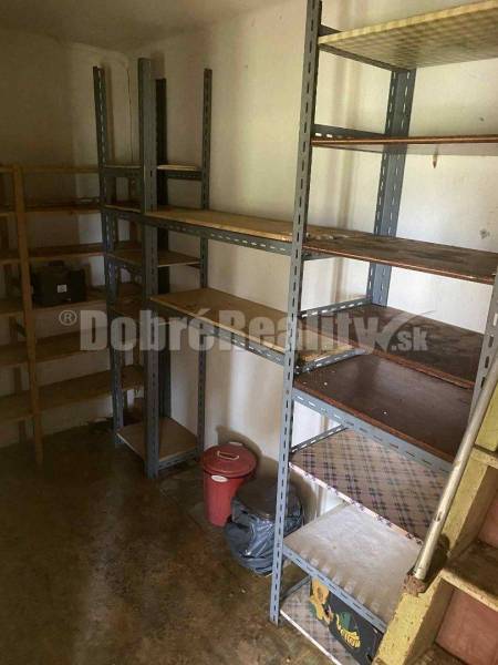 Úložný prostor v rodinném domě s regály z kovu a dřeva.