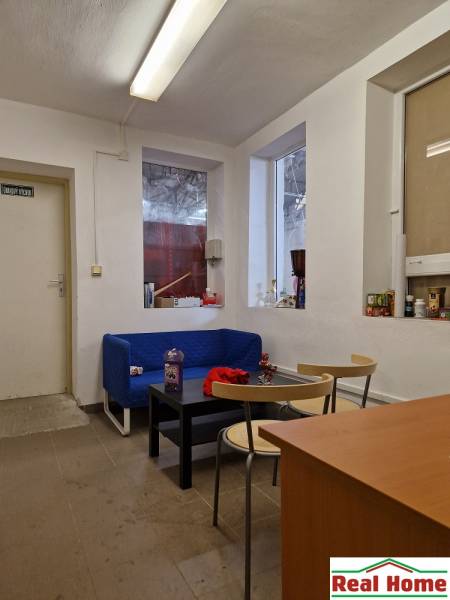 Prostor na ulici Šamorínska s pohovkou, stolky a úložnými prostory, vhodný pro sklady.