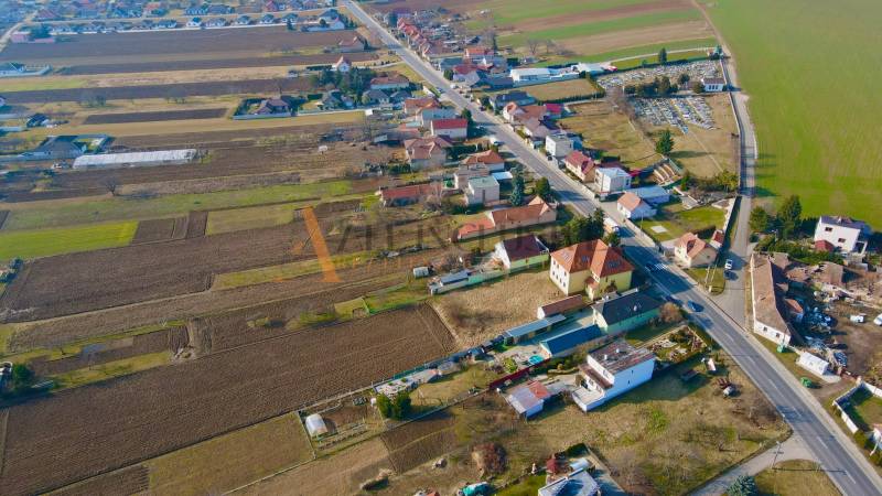 Letecký pohled na Chrabrany v Topoľčanech s venkovskými budovami a poli.