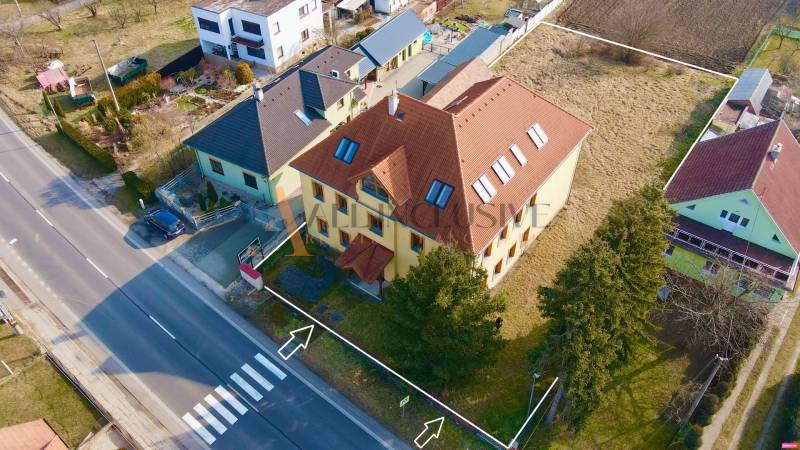 Budova na ulici Chrabrany v Topoľčanech, obklopená domy a zelení.