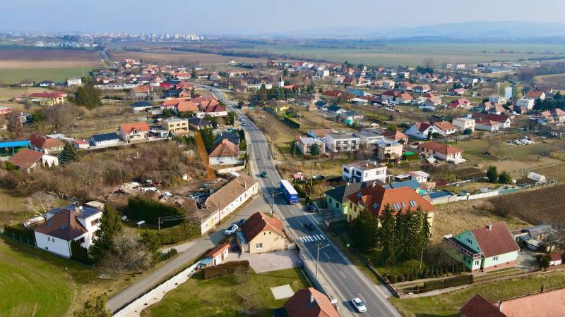 Pohled na domy a ulice v Chrabranech, Topoľčany, pod jasnou oblohou.
