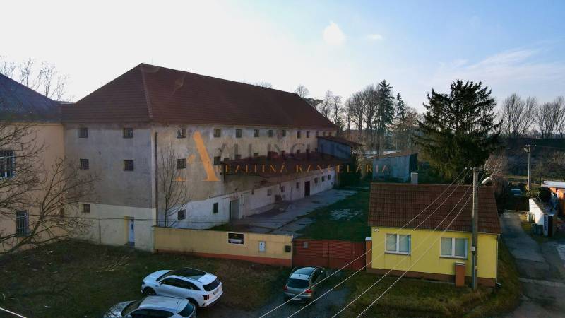 Výrobní prostory v Kovarciach na Hlavní ulici, s prostorným nádvořím a zelení.