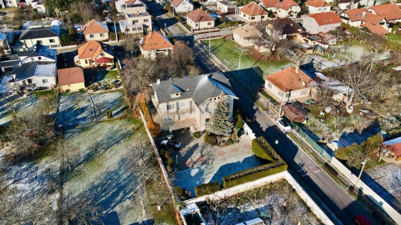 Vila na ulici Sportovců v Topoľčanech, obklopená zahradami a okolními domy.