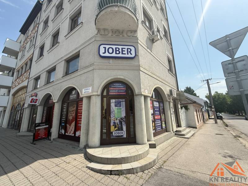Obchodní prostory v Komárně na Petőfiho ulici se sluneční fasádou a reklamními štíty.