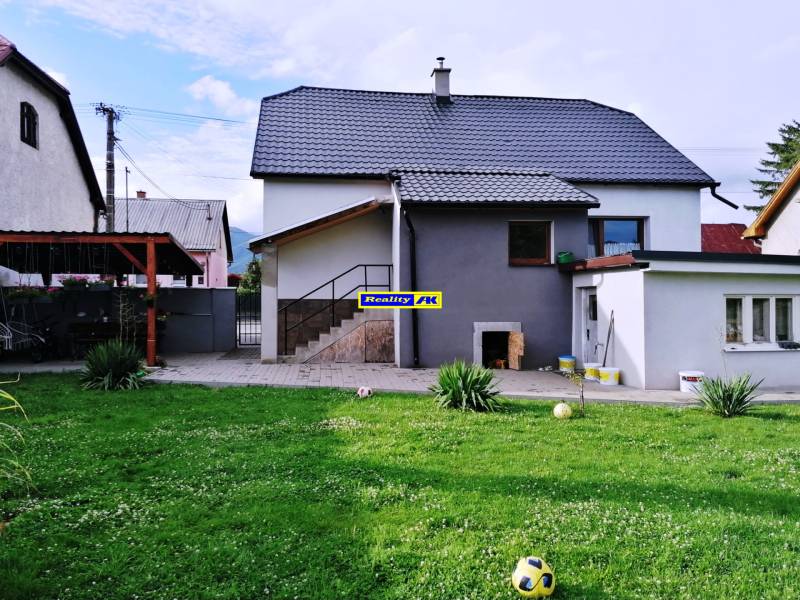 Rodinný dům v Sučanech u Martina s trávníkem a přístřeškem.