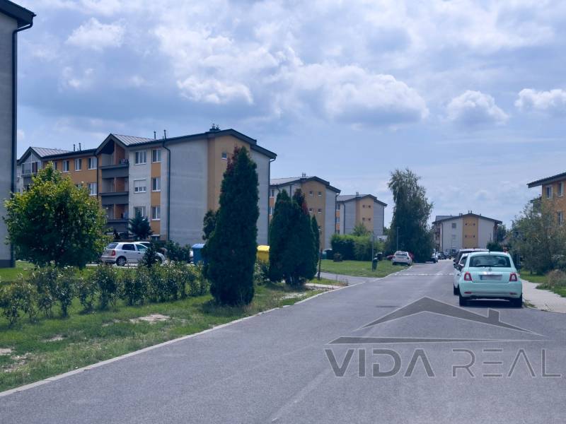 Ulice M.R.Štefánika v Mostě pri Bratislavě se zaparkovanými auty před bytovkami.