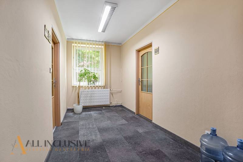 Chodba ve vstupní oblasti kanceláře s květinou a nesenou vodou.