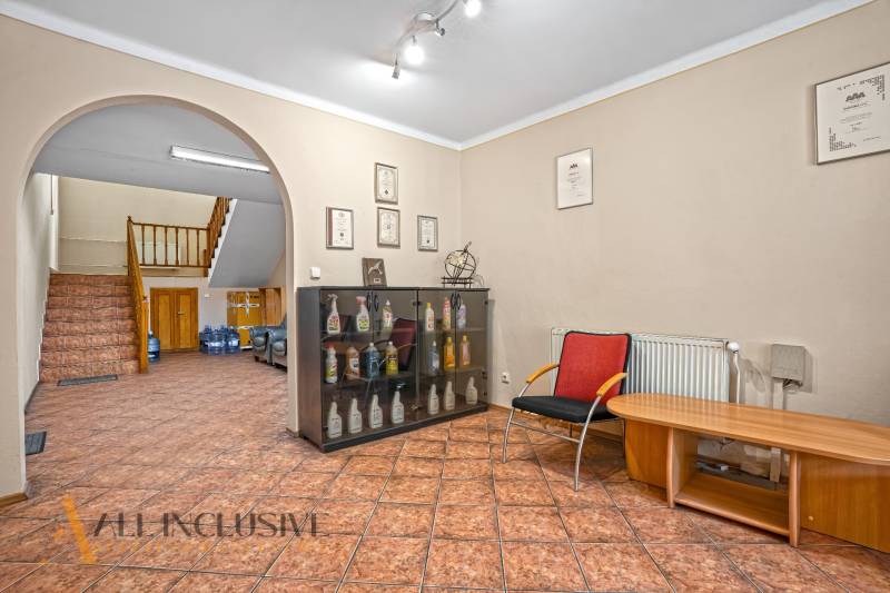 Kanceláře s výstavní skříní, odpočinkovou zónou a schodištěm.