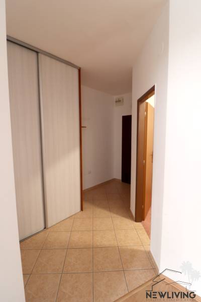 Chodba s vestavěnou skříní a dlažbou v 2-pokojovém bytě.