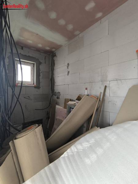 Stavební materiály a elektroinstalace v rozpracované místnosti rodinného domu.