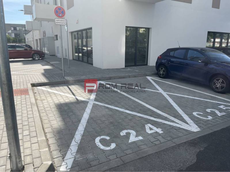 Parkovací místo na ulici Eduarda Wenzla v Bratislavě III před obchodními prostory.
