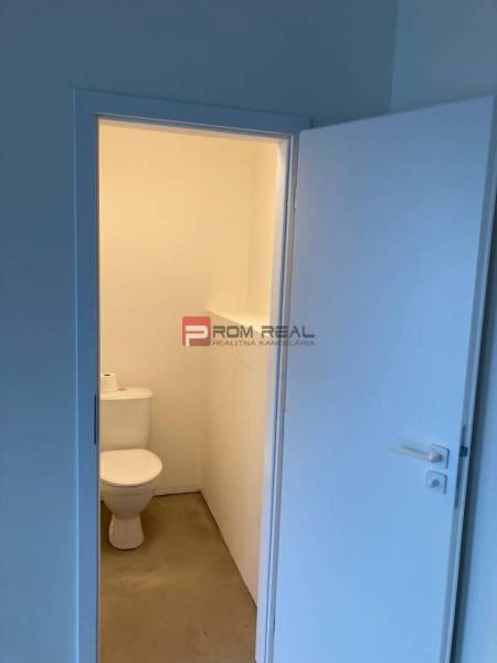 Toaleta v obchodních prostorách s jednoduchým a čistým designem.