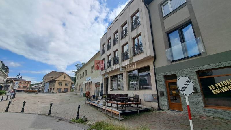 Budova na Mostní ulici v Ružomberku s terasou a okolními historickými stavbami.