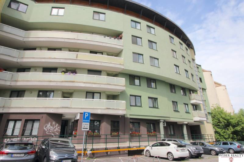 Bytový dům se zakřivenou strukturou, parkovacími místy před vchodem na Žatevné ulici, Dúbravka.