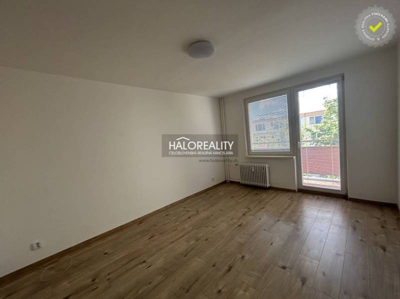 Prostorný pokoj s velkým oknem a balkónovými dveřmi ve 3pokojovém bytě.
