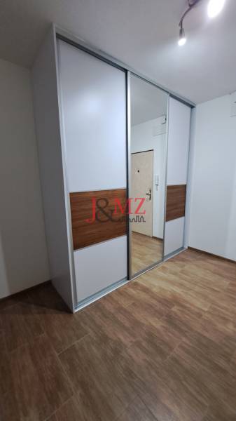 Vestavěná skříň s posuvnými dveřmi a zrcadlem v 2-pokojovém bytě.