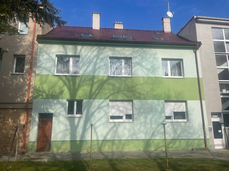 Rodinný dům na Kalinčiakově ulici v Piešťanech, zelená fasáda, stín stromu.