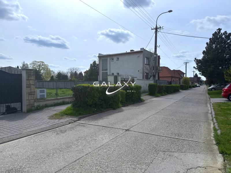 Poklidná ulice se zelení vhodná pro pozemky - bydlení ve Sládkovičově.