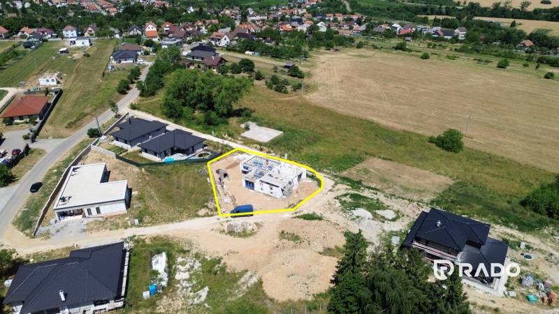 Stavební pozemek rodinného domu v Trenčianskom Jastrabí obklopený přírodou a sousedními domy.