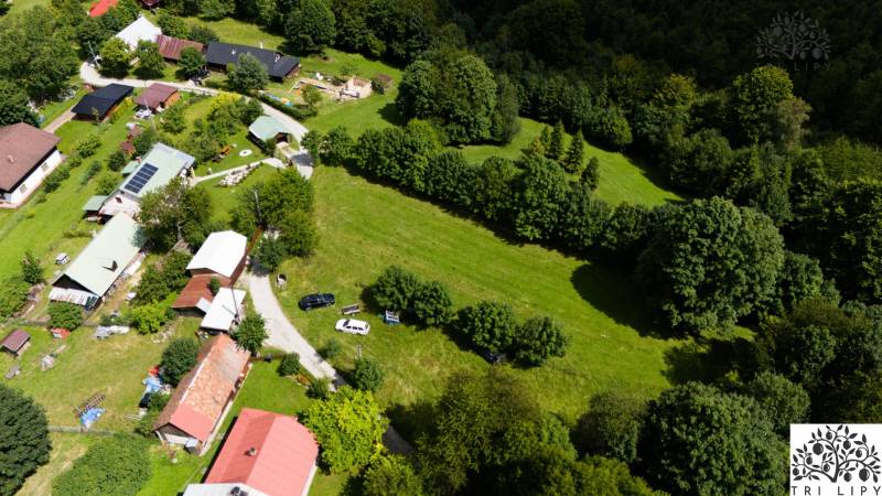 Letecký pohled na rekreační pozemky v Oščadnici obklopené zelení a budovami.