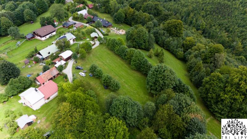 Letecký pohled na rekreační pozemky v Oščadnici, obklopené lesy a domy.