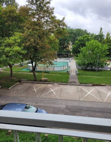 Výhled z 3pokojového bytu v Bratislavě - Ružinově na Měsíční ulici, parkoviště, stromy a hřiště.