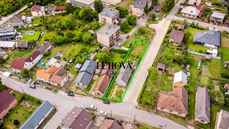 Letecká fotografie ulice Pavla Koyša v Ladcích, znázorňující rodinné domy a okolní zahrady.
