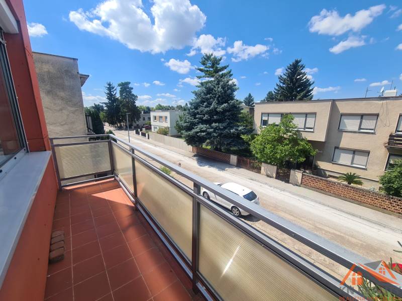 Balkon na rodinném domě v Nových Zámcích s výhledem na tichou ulici a zeleň.