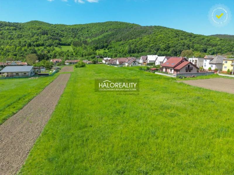 Pozemky - bydlení v Udiči se zelenými loukami a venkovskými domy v blízkosti lesa.
