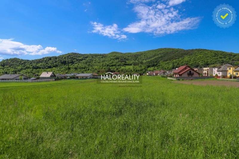 Zeleň a panorama v Udiči, pozemky - bydlení s domy a zalesněnými kopci v pozadí.