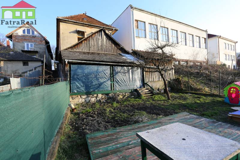 Na ulici Nám. A. Hlinku je vidět starý rodinný dům, dvůr a plot.