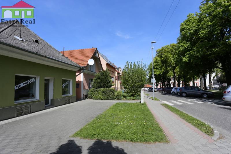 Na ulici Nám. A. Hlinku, rodinný dům, kolem jsou auta a stromy.