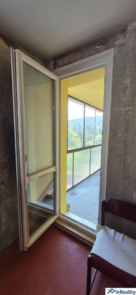 Zasklený balkon s pohovkou v 3-pokojovém bytě.