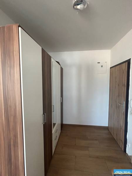 Chodba se skříní a dřevěnými dveřmi ve 3-pokojovém bytě.