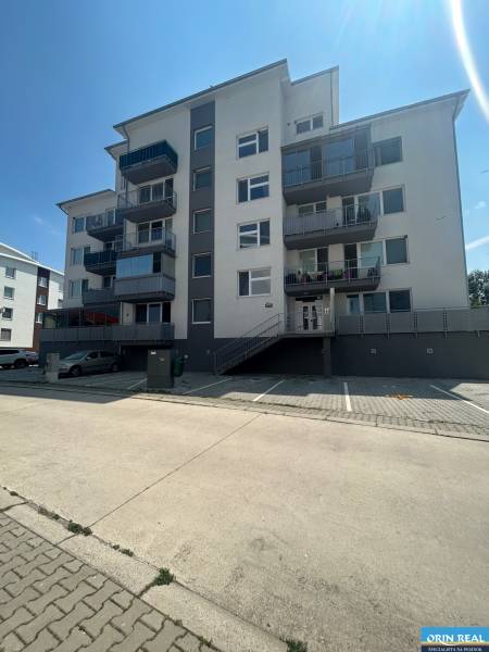 Pětipatrový bytový dům se schodištěm a parkovištěm na Slavomírově ulici ve Slovenském Grobu.