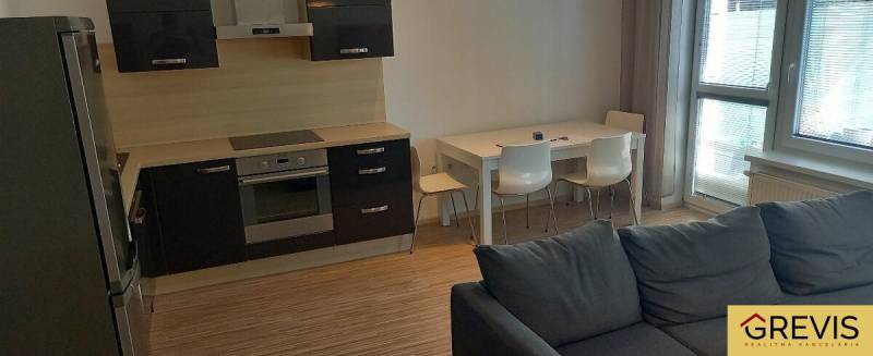 Kuchyně a obývací pokoj v 2pokojovém bytě s moderní kuchyňskou linkou a jídelním stolem.