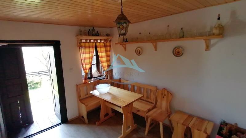 Venkovský interiér nabízí dřevěnou lavici a stůl, nábytek dolaďuje atmosféru rodinného domu.