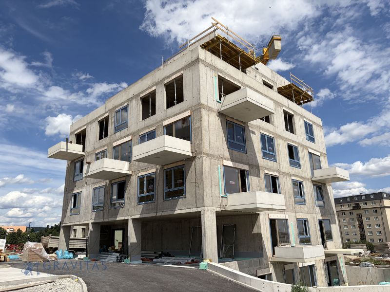 Rozestavěný bytový dům v Bratislavě - Rači s viditelnými balkony a okny.